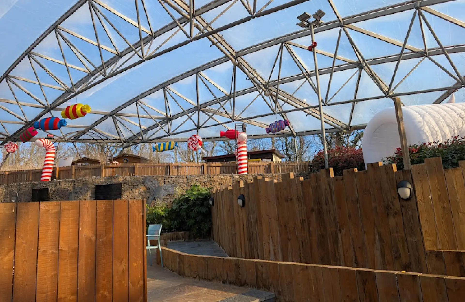 Covered entrance area with colourful candy-themed decorations and wooden fencing at Blue Lagoon Water Park, part of Bluestone National Park Resort in Wales.