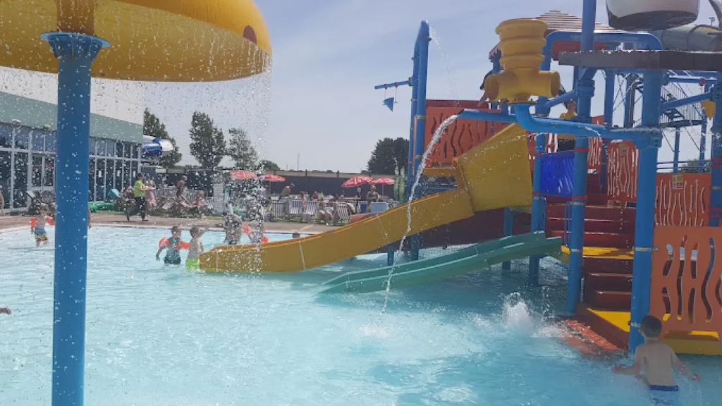Children playing with water features, tipping buckets, and slides at the outdoor splash area of Brean Splash Waterpark Somerset.
