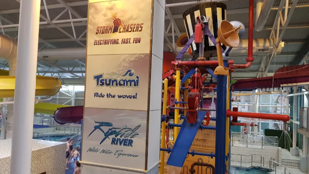 Storm Chasers, Tsunami and Riptide River signs beside colourful splash tower at The Time Capsule Water Park Scotland, Coatbridge.