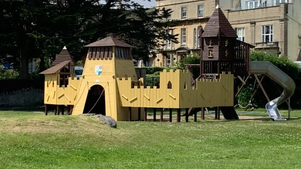 Castle-themed wooden play structure with turrets and slide at the Water Adventure Play Park in Weston-super-Mare Play Park.