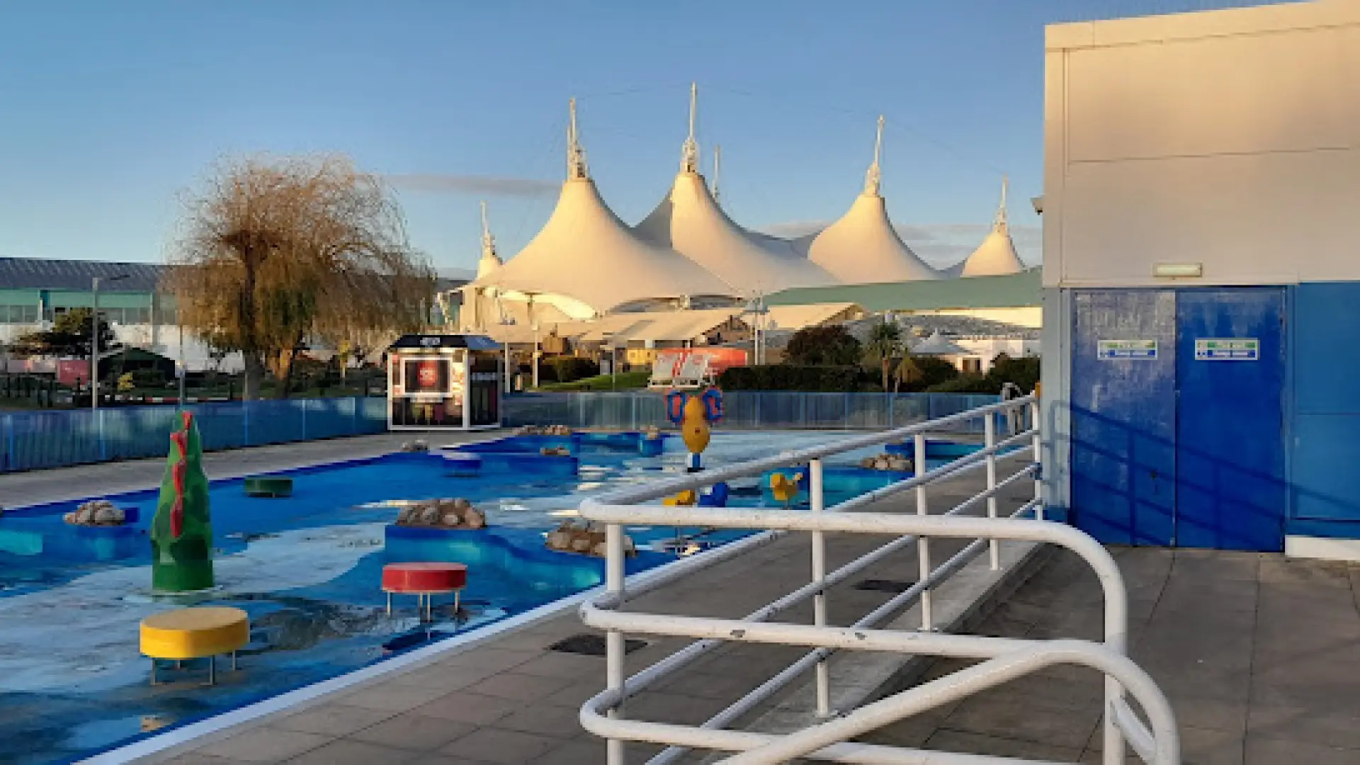 Outdoor splash zone at Butlins Splash Waterworld Minehead with colorful water features and white pavilion structures in the background.