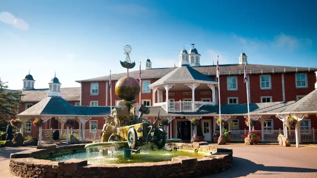 Fountain and entrance of Alton Towers Hotel with themed sculpture and red-brick building under blue sky — one of the top-rated places to stay near Alton Towers.