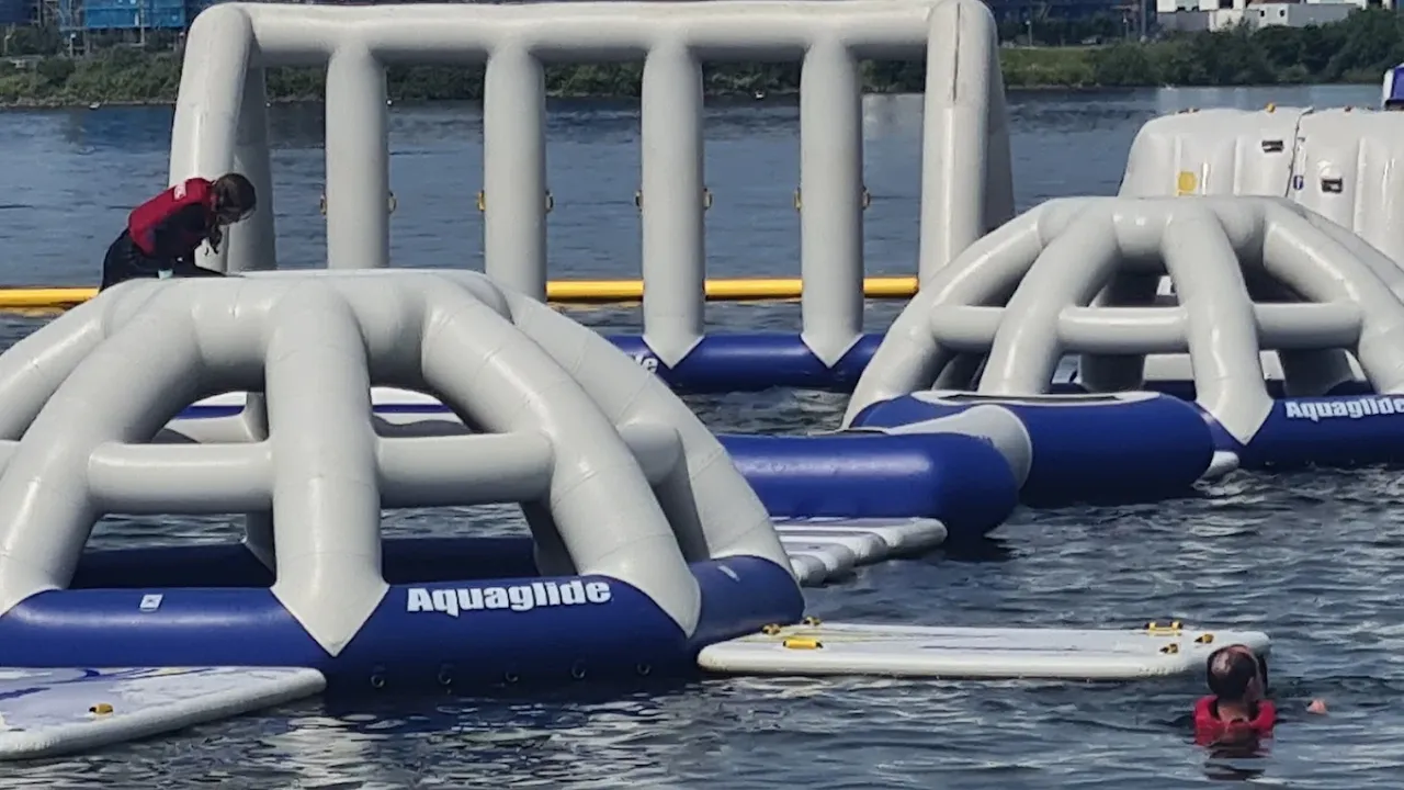 Inflatable water course elements floating at Aqua Park Cardiff on a sunny day.