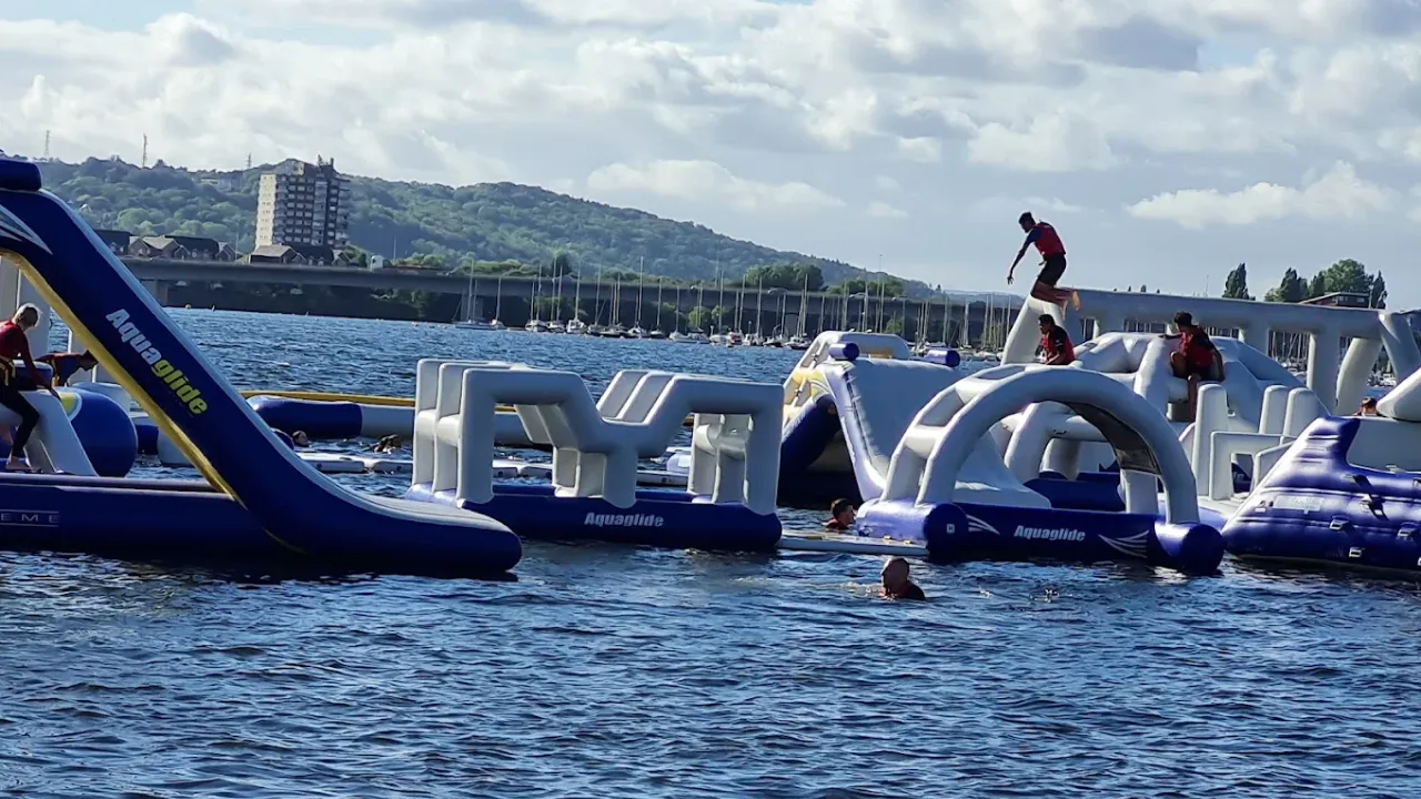 Aqua Park Cardiff visitors using inflatable climbing and balance structures.