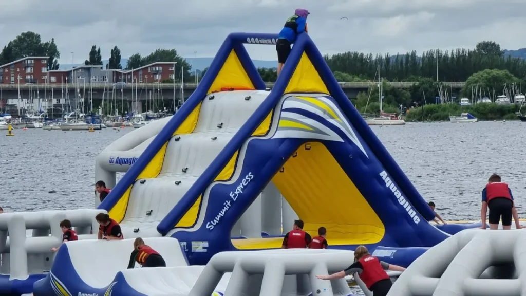 Large inflatable slide tower “Summit Express” with climbers at Aqua Park Cardiff.