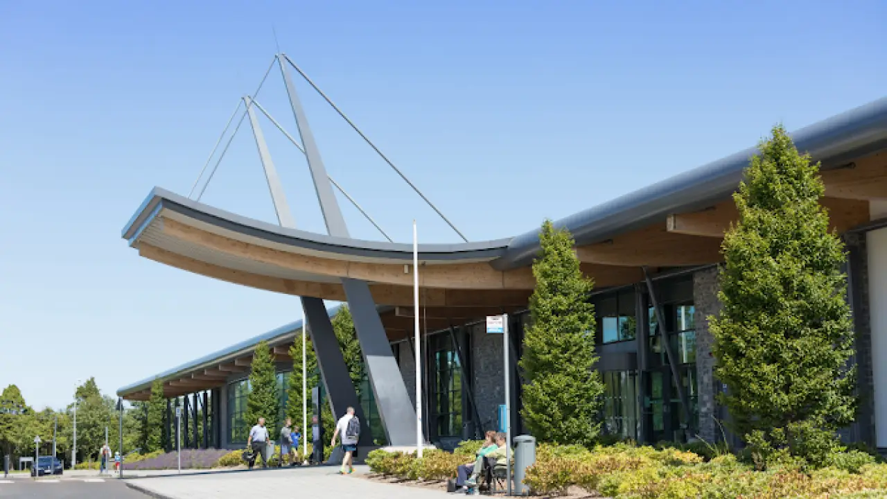Exterior view of Bangor Aurora Leisure Centre entrance with modern architecture and visitors arriving.