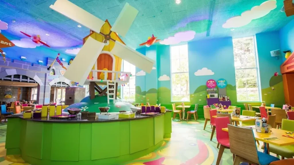 Colourful family restaurant at CBeebies Land Hotel with windmill display, cartoon walls, and child-friendly seating