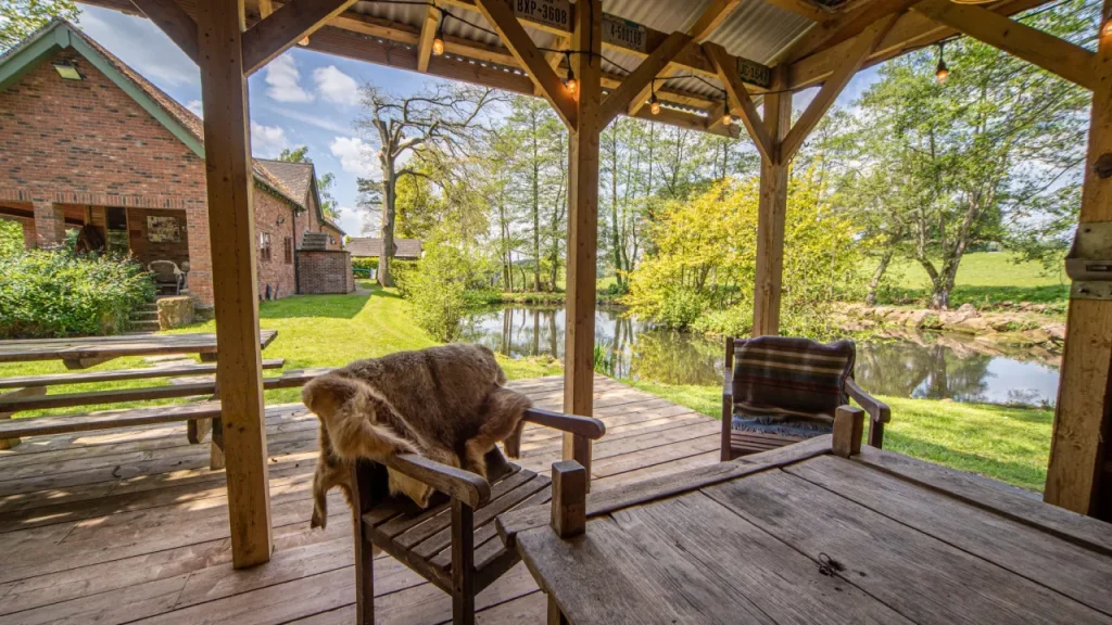 Wooden veranda overlooking a serene pond at Chained Oak Farm B&B near Alton Towers.