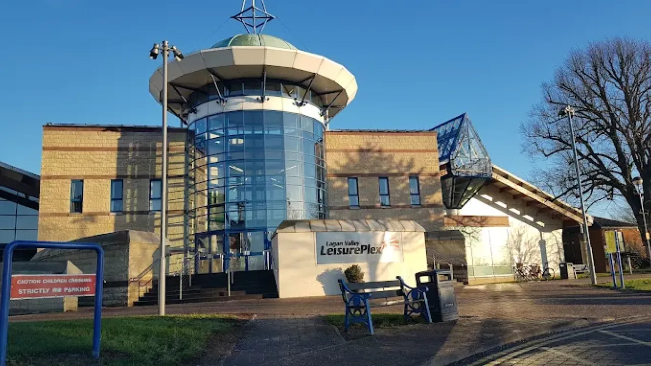 Front view of Lagan Valley LeisurePlex in Lisburn featuring the main glass entrance and signage on a sunny day.