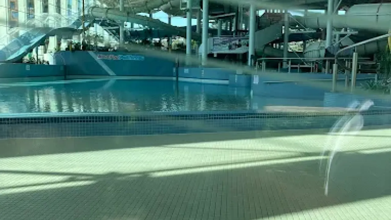Interior of The LC Swansea waterpark showing the Masterblaster slide, still water in the pool area, and surrounding aquatic play structures.