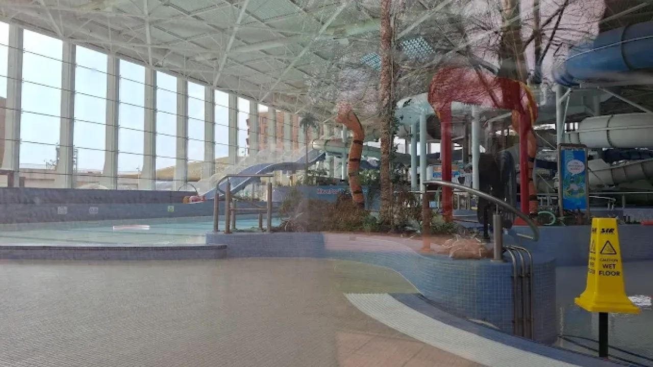 View inside The LC Swansea waterpark showing shallow pools, mini slides, jungle-themed splash features, and large windows with natural light.