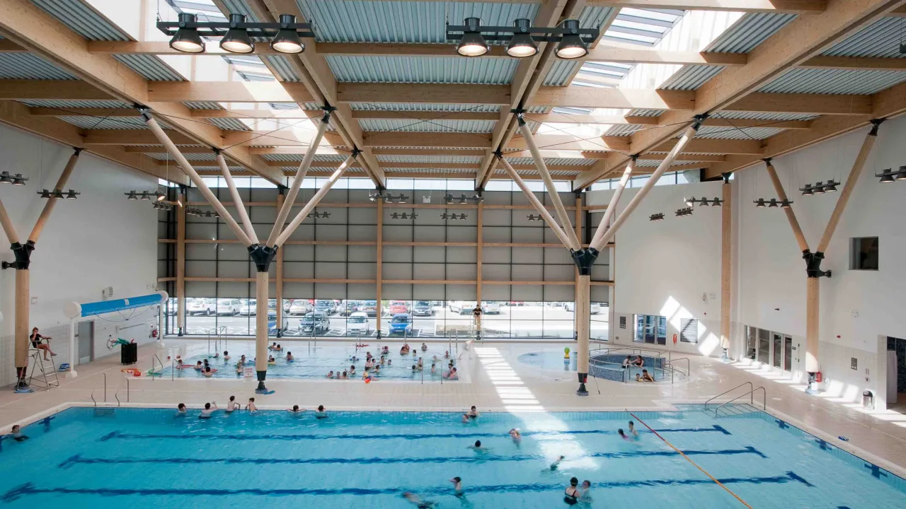 Indoor view of Omagh Leisure Complex showing main swimming pool, leisure pool, and children enjoying water activities.