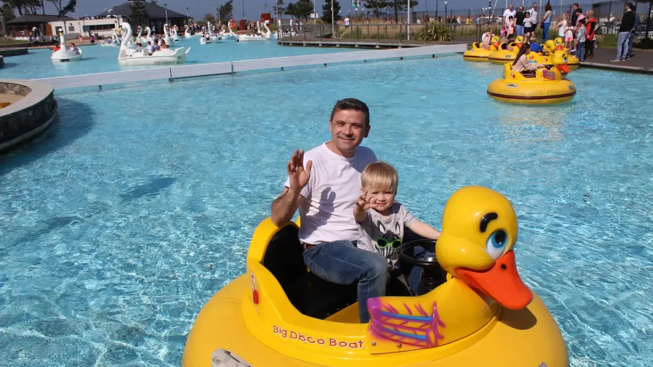 Father and young son riding a yellow Disco Duck boat at Pickie Funpark water attraction in Bangor, Northern Ireland.