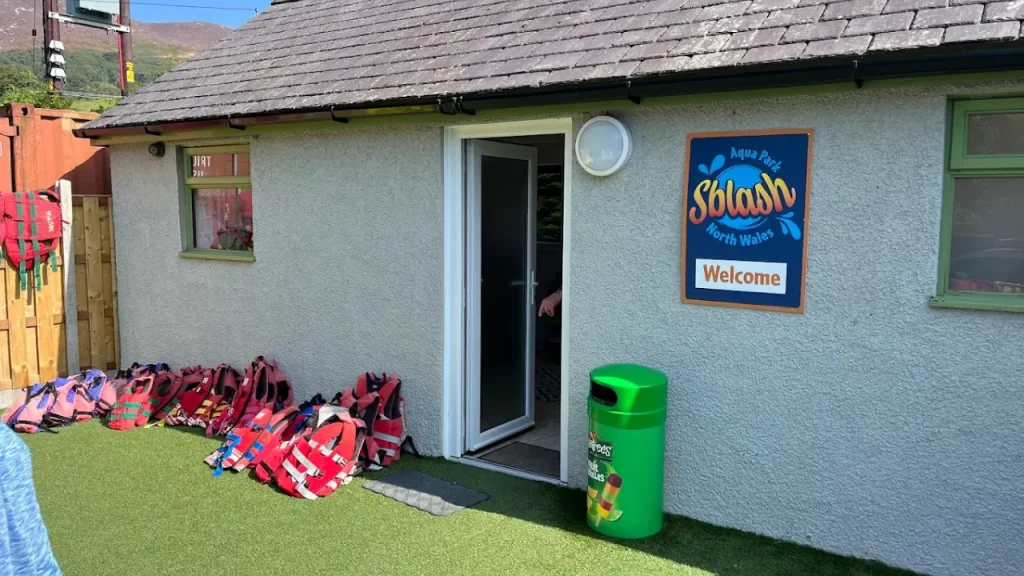 Sblash Aqua Park welcome area with safety gear including red life jackets outside the entrance cabin.