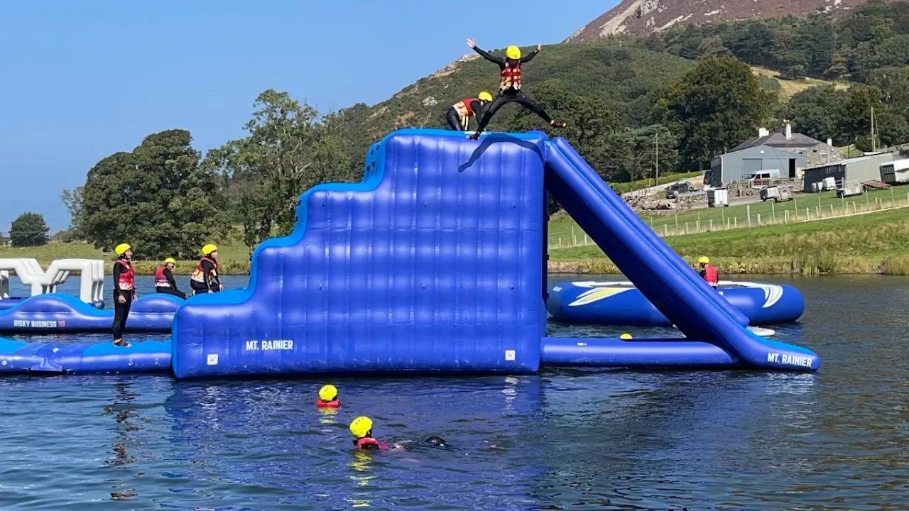 Person jumping from high inflatable slide named Mt. Rainier at Sblash Aqua Park on Bala Lake.