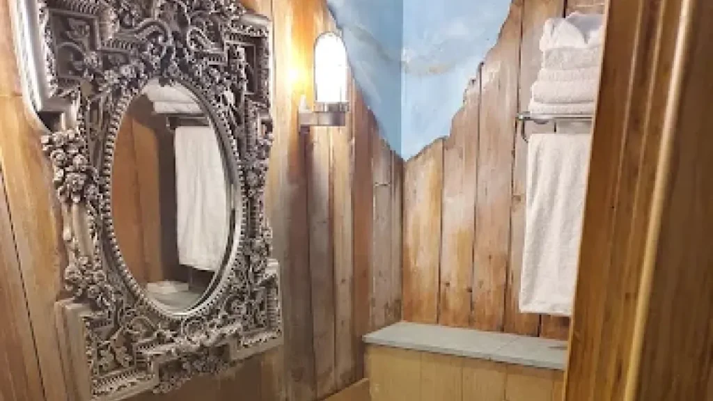 Splash Landings Hotel rustic-themed bathroom with ornate framed mirror, timber wall cladding, and fresh towels arranged for guest comfort near Alton Towers.