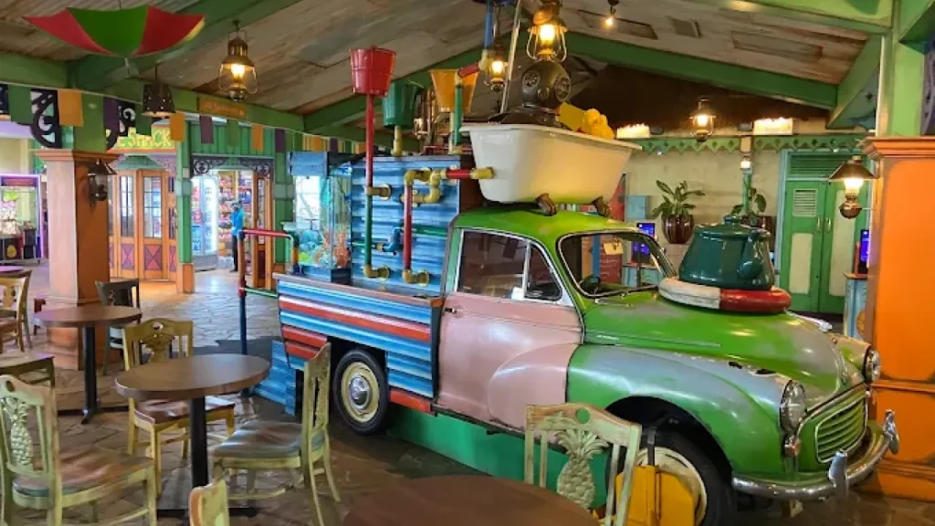 Eccentric car display with bath tub and steampunk pipes in the lively, island-inspired lounge at Splash Landings Hotel, one of our fun and unique places to stay near Alton Towers.