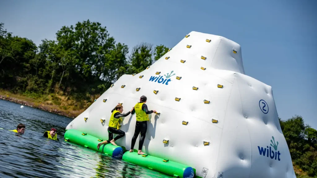Participants scaling the inflatable iceberg climbing wall at Splash Outdoor Waterpark AquaPark in Northern Ireland.