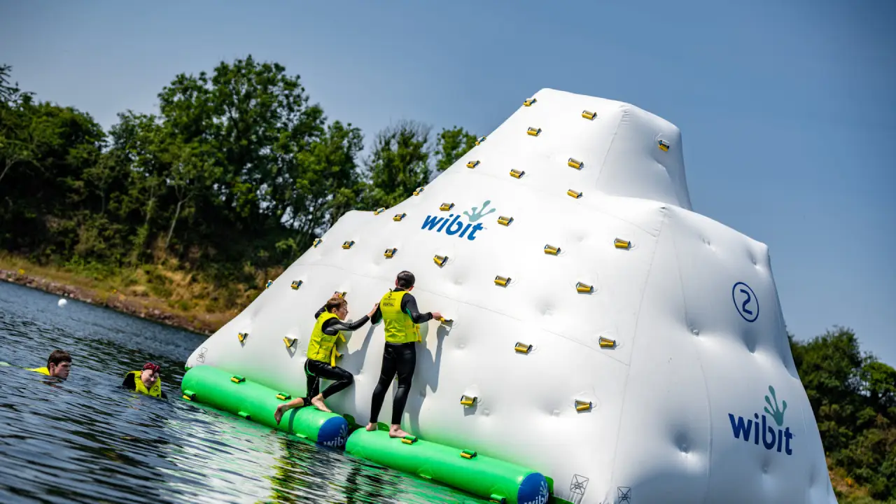 Participants scaling the inflatable iceberg climbing wall at Splash Outdoor Waterpark AquaPark in Northern Ireland.