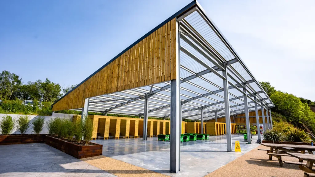 Spacious changing facilities and lockers under a covered area at Splash Outdoor Waterpark in Northern Ireland, with wooden cubicles and seating.