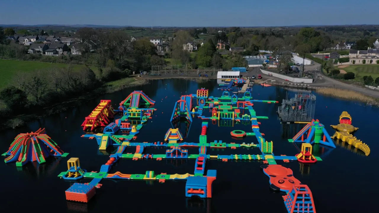 Aerial photo of the lake Kilrea waterpark’s colourful floating obstacle course — slides, ramps and balance beams on a spring-fed lake in Kilrea, County Londonderry.