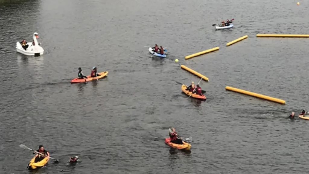 Paddlesports at the lake Kilrea waterpark — kayaks and a swan pedalo in the calm hire zone, a family-friendly alternative to the floating obstacle course.