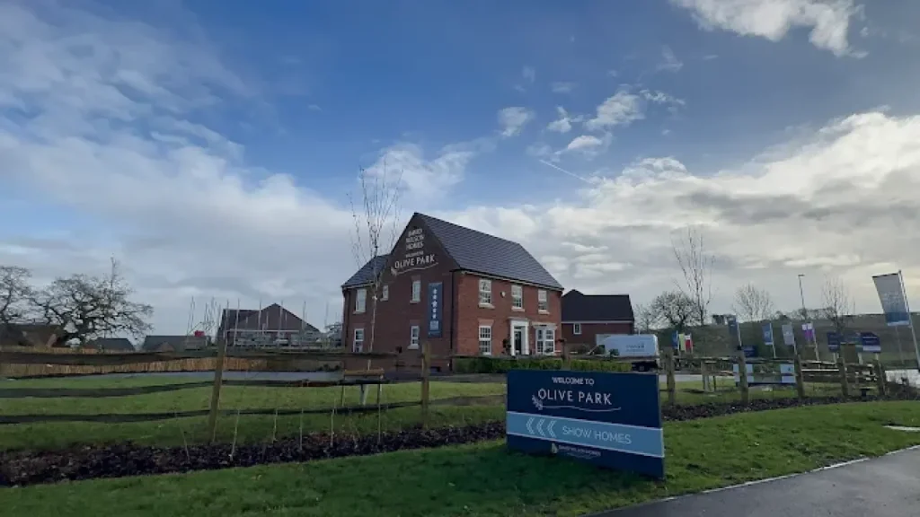 Exterior of The White Hart Hotel with red-brick façade and Olive Park signage under a partly cloudy sky