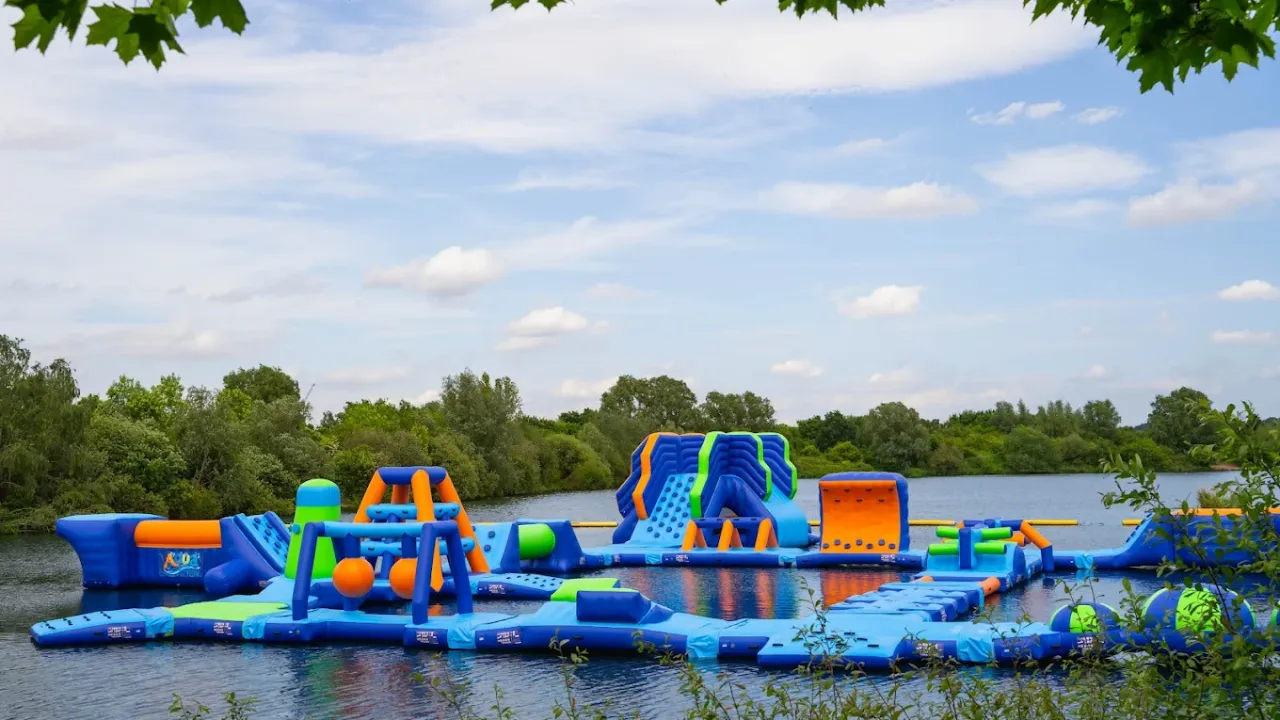 Scenic view of Aqua Action inflatable water park course floating on the lake at Fairlop Waters, Essex.