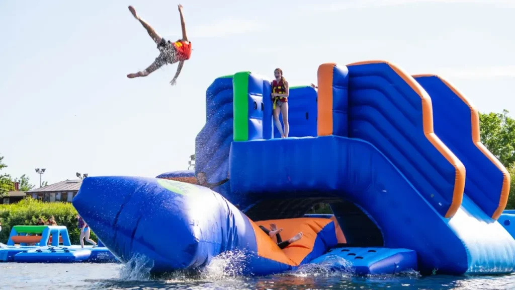 Person flying into the air from the blast bag inflatable at Aqua Action water park near Ilford.
