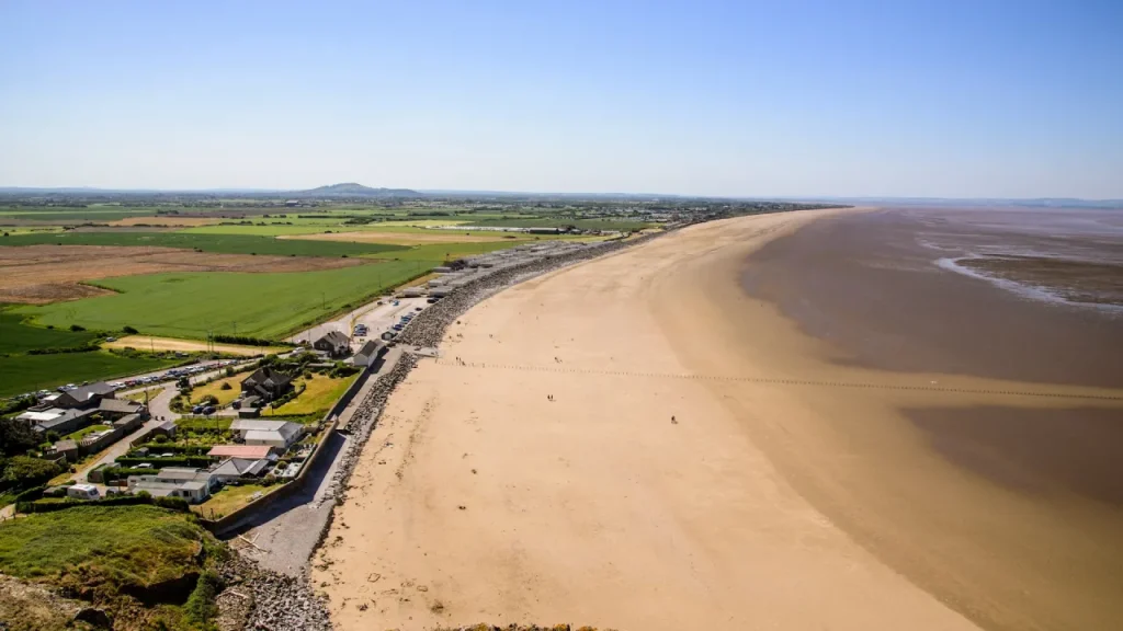 Panoramic coastal view from Brean Down showing Brean Beach, Somerset farmland, and the Bristol Channel at low tide, near Brean Leisure Park.