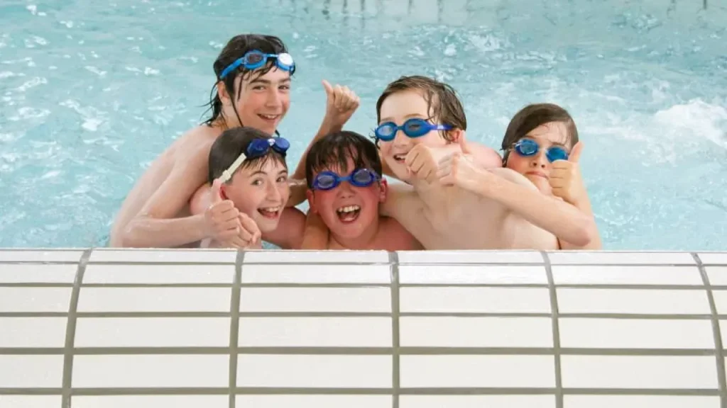 Group of smiling children wearing goggles in a pool at Dundee Olympia leisure centre.