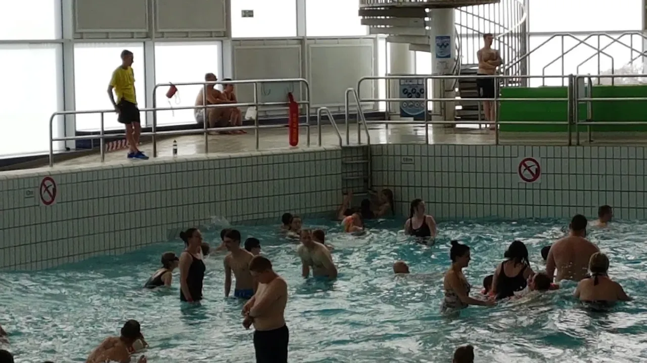 Crowded wave pool at Dundee Olympia with children and adults swimming under lifeguard supervision.