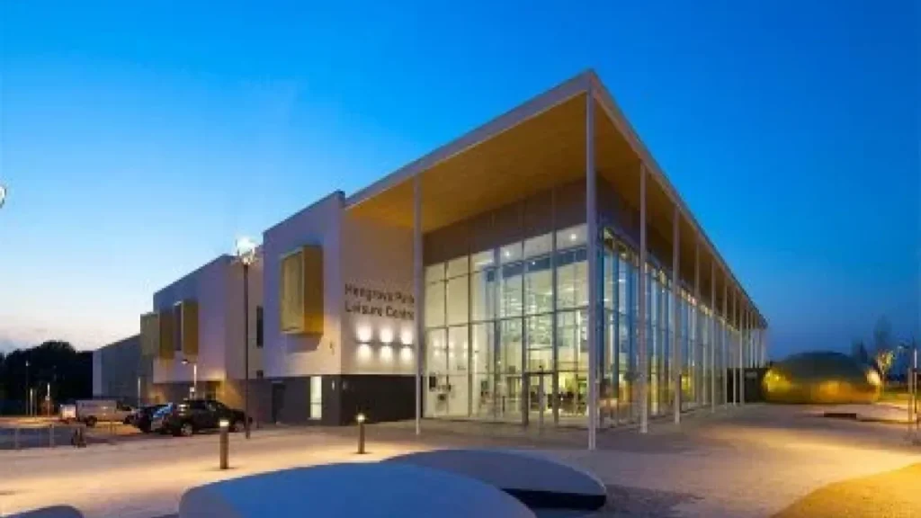 Front view of Hengrove Park Leisure Centre Bristol with modern glass architecture at sunset.