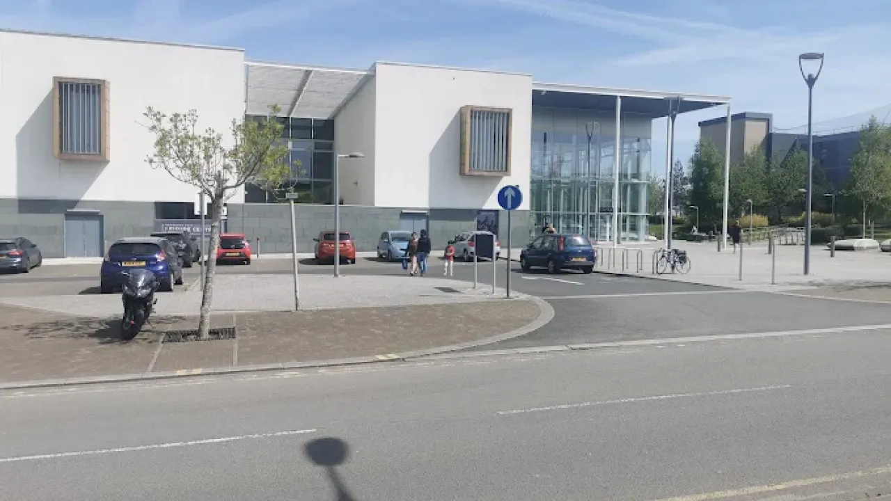 Front car park and glass entrance of Hengrove Park Leisure Centre with visible cycle storage and footpath.