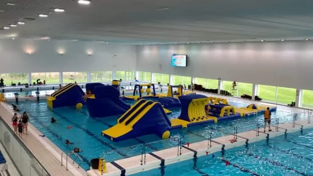 Hengrove Park Leisure Centre’s indoor pool with large blue and yellow inflatable water obstacle course.