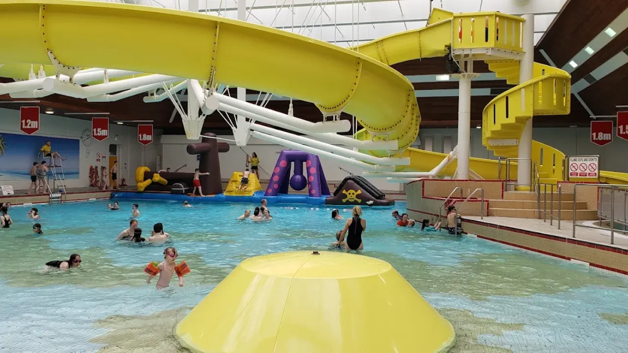 Children and adults swimming and playing on inflatables at Lagoon Leisure Centre’s indoor leisure pool.