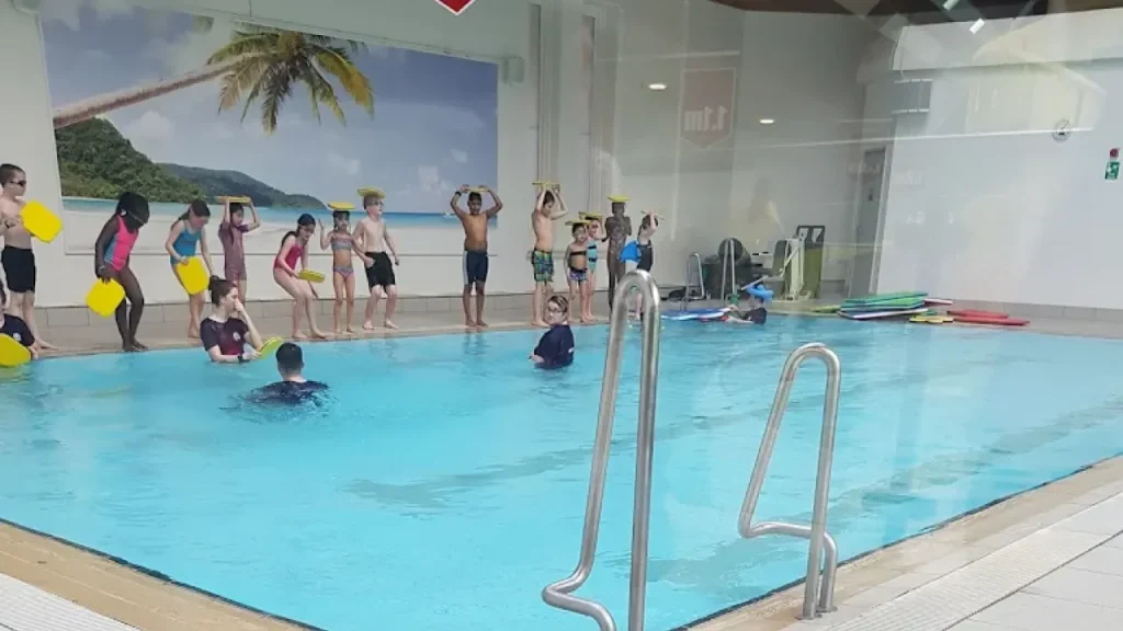 Children participating in a swim lesson at Lagoon Leisure Centre’s small pool with swim teachers present.