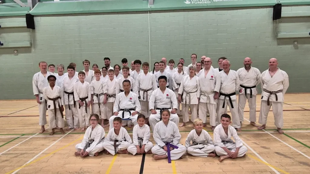 Karate class posing inside Lagoon Leisure Centre sports hall with students in traditional uniforms.