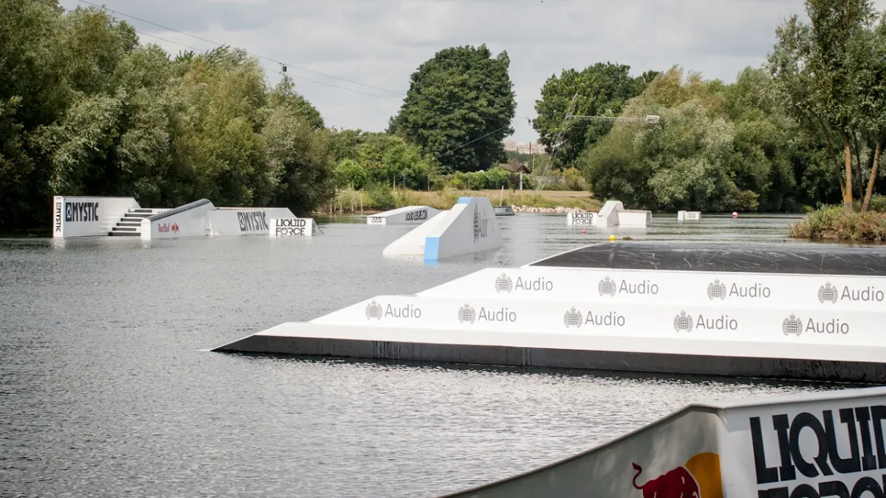 Wakeboarding ramps at Liquid Leisure Aqua Park Windsor with forested surroundings and branded obstacles.