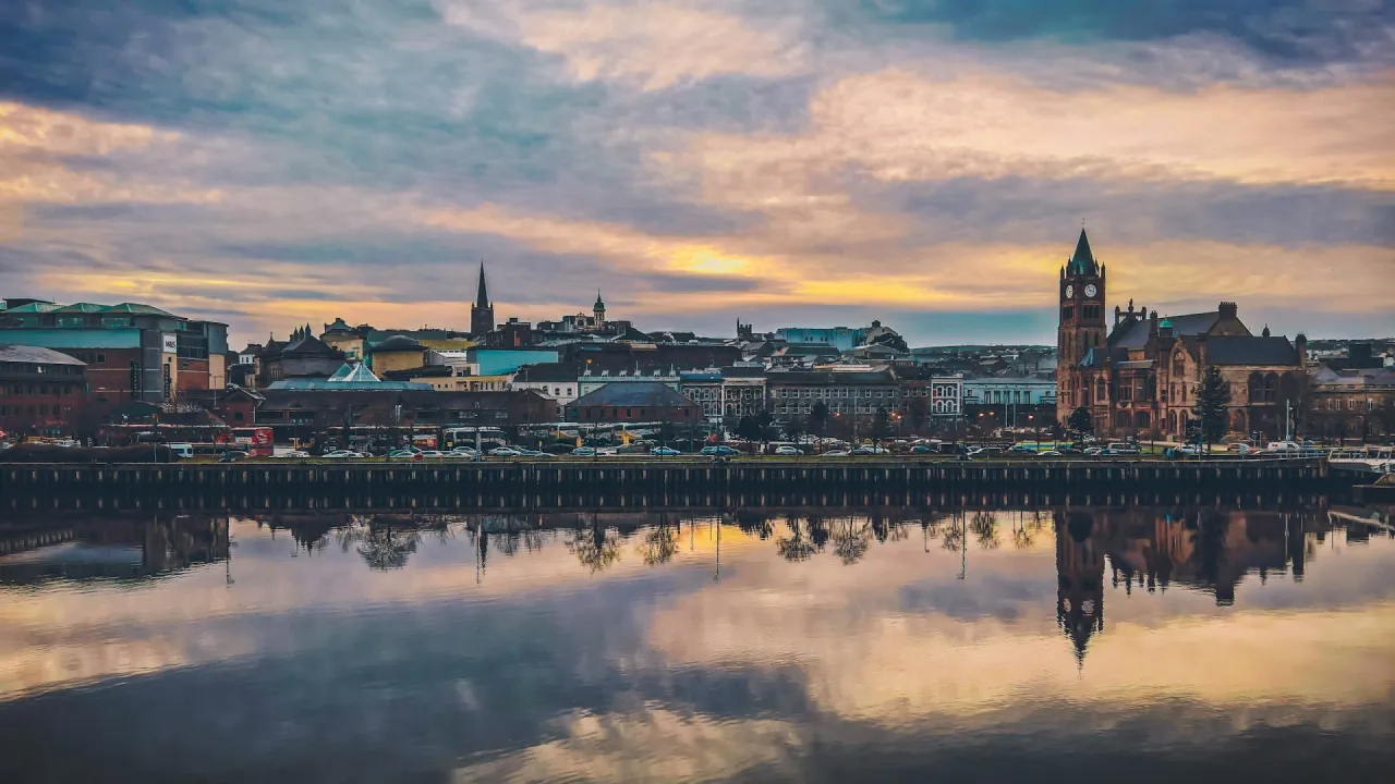 The sun sits low over the Cityside and the River Foyle, Londonderry, Northern Ireland, UK