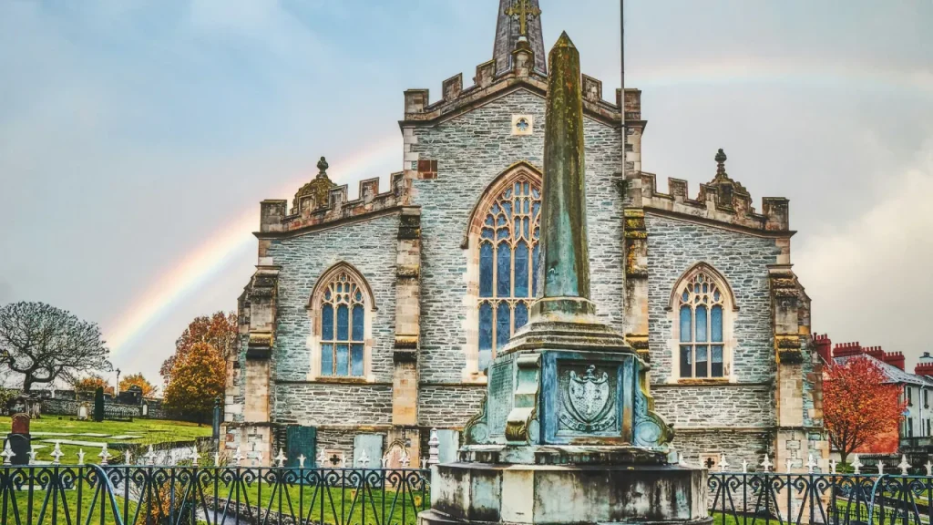 St. Columb’s Cathedral with a rainbow in the sky, viewed from the Derry City Walls in County Londonderry, Northern Ireland.