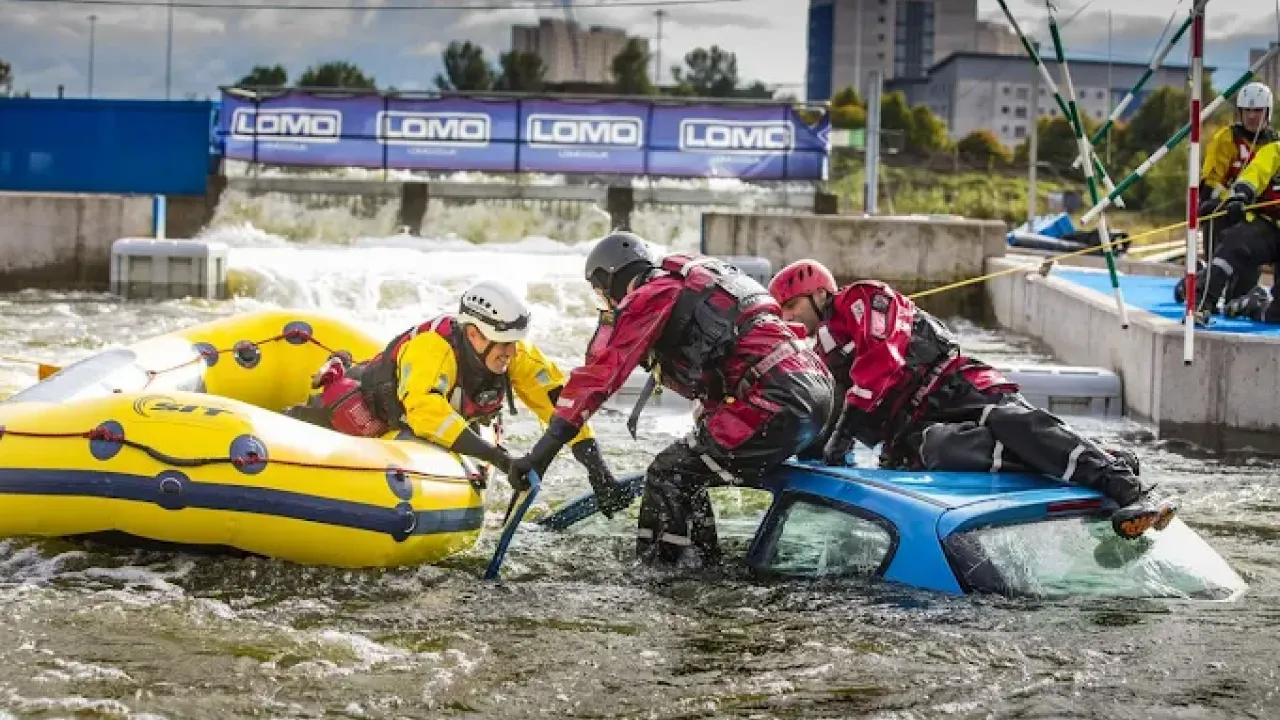 Rescue team performing flood rescue training with a car and inflatable raft at Pinkston Watersports Glasgow.