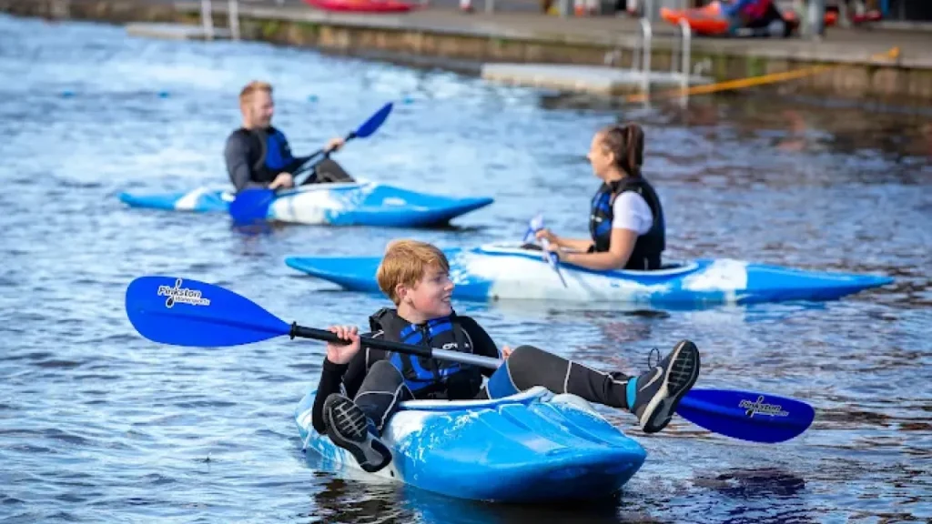 Children and young adults kayaking on the flat water basin at Pinkston Watersports in Glasgow.