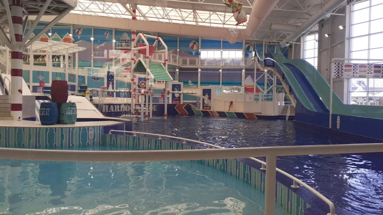 Wide view of Splashaway Bay’s main indoor pool and play structures, including slides and water cannons.