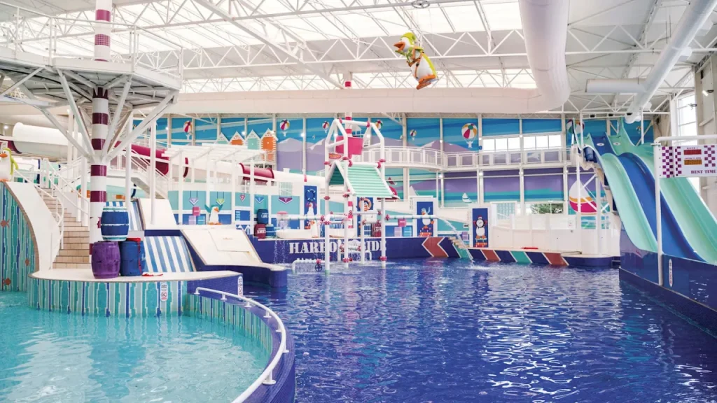 Central swimming area at Splashaway Bay with colourful splash zone, barrels and flumes under glass roof.
