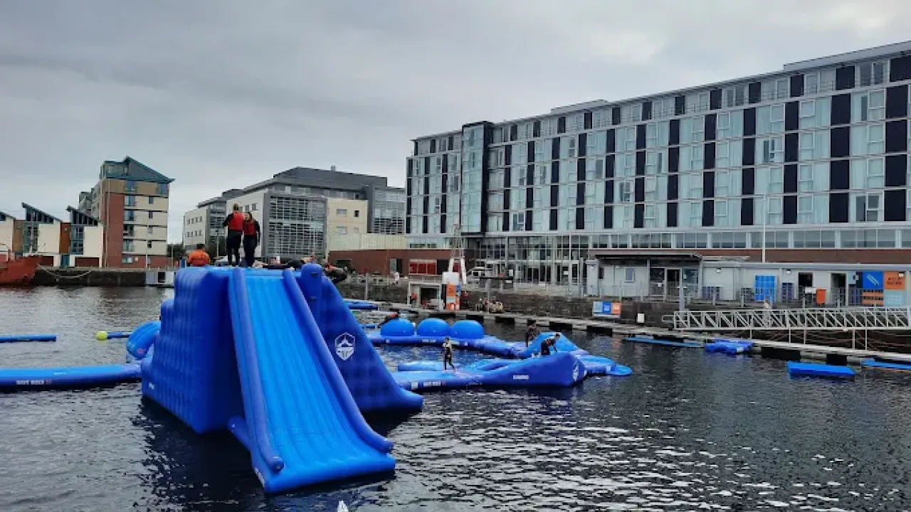 Aqua park inflatables with hotel and quay buildings in background at Wild Shore Dundee.
