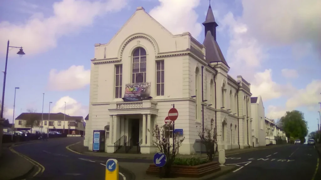 Ballymoney Town Hall in Northern Ireland, a historic white building with arched windows and a central tower, serving as a museum and arts venue.