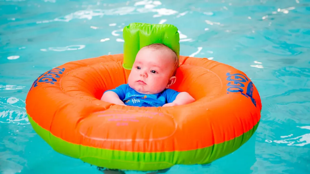 Baby wearing inflatable swimming ring and swim cap floating safely in Perth leisure pool's shallow water area designed for infants and toddlers